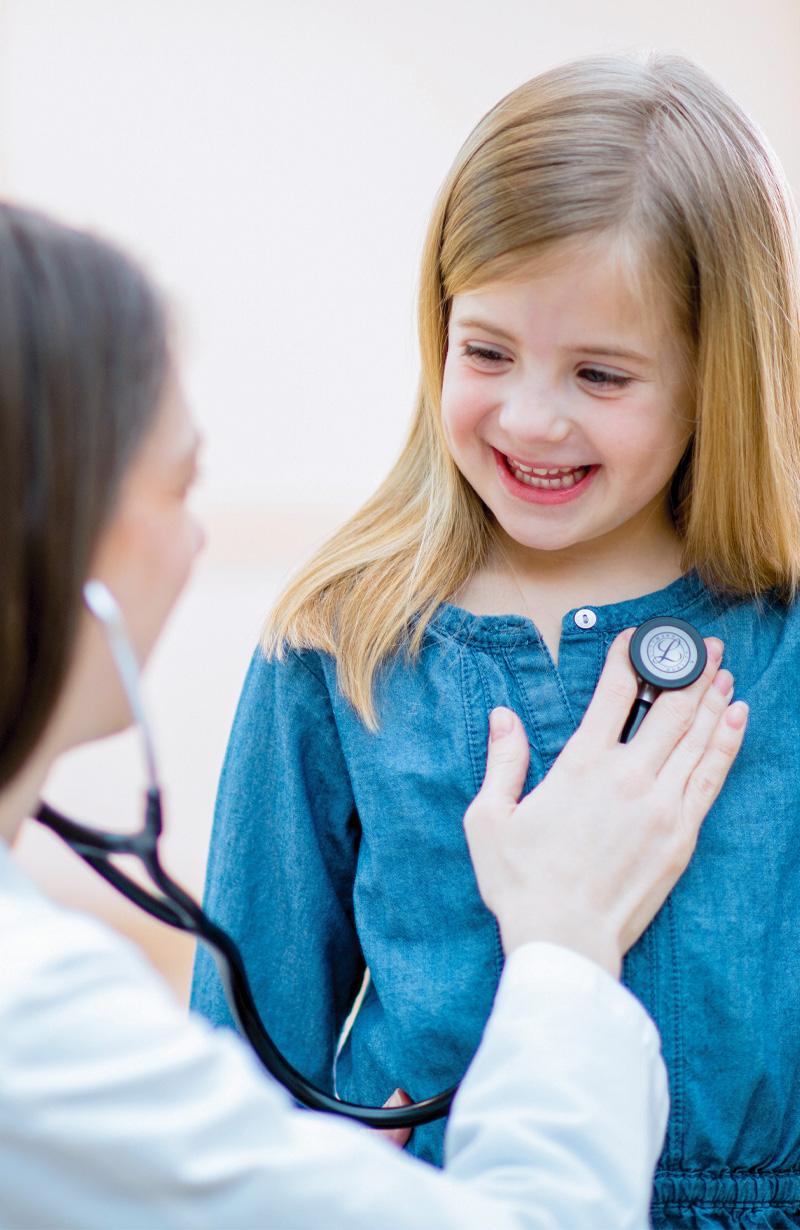 Emplify Health provider Kim Breidenbach listening to young girl's heartbeat with stethoscope. 